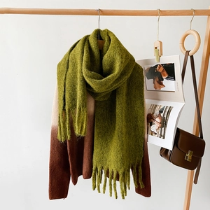 Detail of green mohair scarf featuring thick texture and elegant long tassels