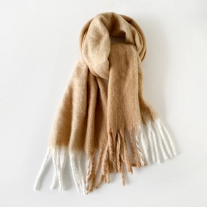 Macro detail of camel mohair scarf featuring soft textured fringe and white color block accent