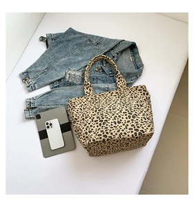 Flat lay of leopard print canvas tote bag with tablet and casual denim jacket accessories