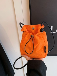 Minimalist orange nylon drawstring crossbody mini bag with checkered texture and strap