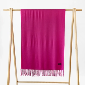 Detail showing the fine fringe and soft cashmere texture of a vibrant pink scarf