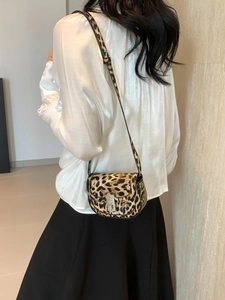 Fashionable leopard print underarm bag shown from a back perspective on a model