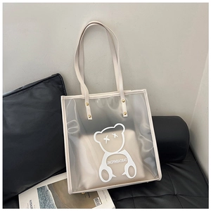 Detail of transparent PVC tote bag with bear print, leather liner and gold rivets