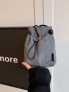 Lightweight grey ripstop nylon drawstring bucket bag with minimalist check pattern