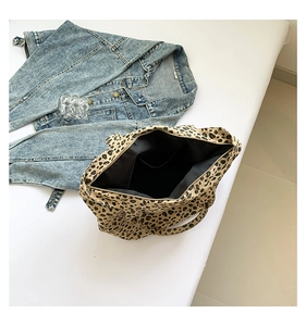 Detailed view of leopard print tote bag interior with black lining and side pocket