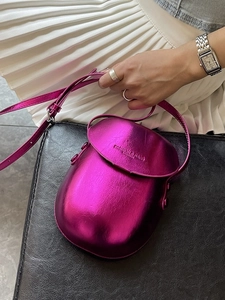 Metallic magenta saddle bag with fashion embossing shown in a high-fashion summer styling