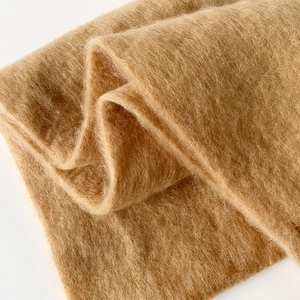 Detailed macro view of soft camel mohair fabric texture with long plush fibers