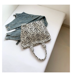 Detailed view of leopard print canvas tote bag styled with a blue denim jacket