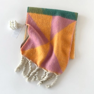 Detailopname van geometrische geblokte mohair sjaal met dikke witte franjes eraan