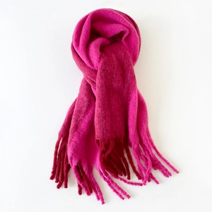 Close-up of fluffy bright pink mohair scarf texture with long fringe tassels details