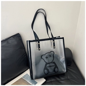 Detail of transparent PVC tote bag with cartoon bear print and black leather handles