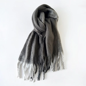 Detailed view of grey to white gradient mohair scarf with thick warm fringe tassels