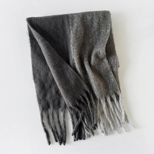 Close-up of grey gradient mohair scarf texture featuring elegant long fringe details