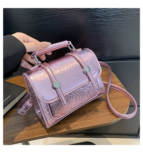 Close-up of pink metallic textured satchel with glossy crinkled finish and metal buckle