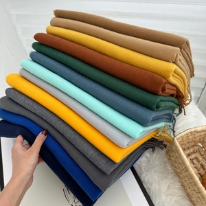 Stacked display of colorful winter scarves with fringe detailing in soft cashmere feel