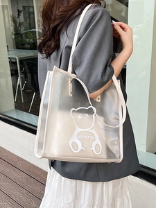 Transparent PVC tote bag with bear print and inner pouch carried by model outdoors
