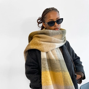Detail of yellow and grey plaid scarf showing thick fuzzy texture and warm winter material
