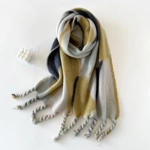 Detail van zachte mohair sjaal met kleurblokken en dikke gevlochten franjes als accenten