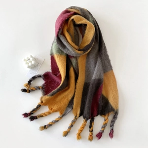 Detailweergave van de dikke mohair sjaal met kleurrijk patchwork en grove geknoopte franjes