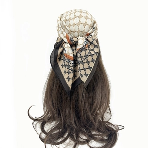 Detail of luxury cashew flower silk scarf tied as headscarf on long brown hair