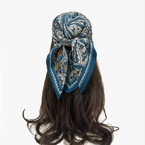 Navy blue paisley satin square scarf worn as a headwrap on wavy brown hair