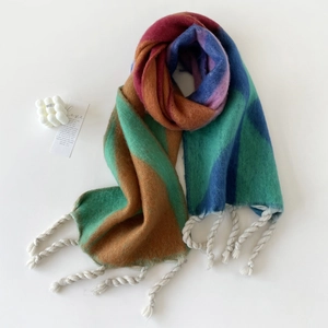 Detail van de meerkleurige mohair sjaal met geometrische blokken en witte kwastjes