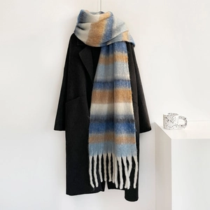 Primer plano de bufanda gruesa de mohair a cuadros con rayas azules y camel y borlas