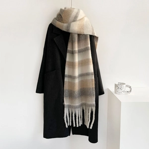 Detalle de bufanda gruesa de mohair a rayas beige y gris con suaves flecos largos