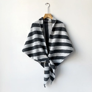 Macro shot of striped knit shawl featuring grey and white horizontal patterns and fine texture