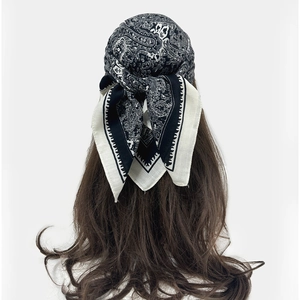 Detail of vintage black and white paisley cotton linen scarf worn as a headpiece on long hair