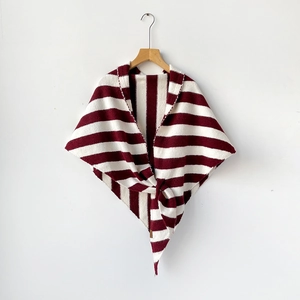 Detail of red and cream striped wool knit shawl featuring a stylish knot decoration