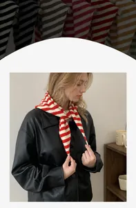 Detail van een rood-wit gestreepte gebreide sjaal over een zwart leren jasje gedrapeerd