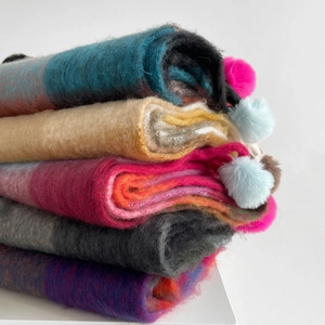 Thick knit colorful rainbow plaid scarf with decorative pom-poms for winter warmth