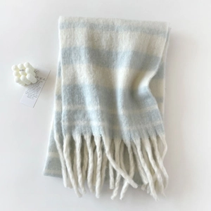 Detalle de bufanda de rayas azul claro y beige con textura suave y acabados de flecos largos