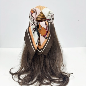 Close-up of retro paisley silk scarf with equestrian patterns worn as a headscarf