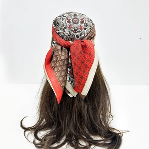 Detailed view of paisley and polka dot pattern mix on vintage style silk scarf