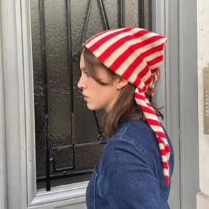 Détail d'un foulard en tricot à rayures rouges et beige avec lanières au style vintage