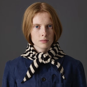 Détail d'une écharpe en laine à rayures noires et blanches avec veste bleu marine