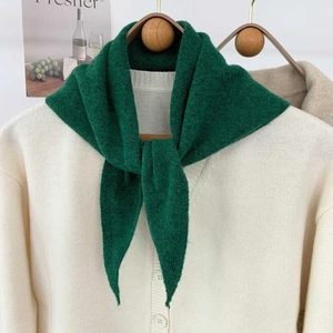 Détail d'une écharpe triangle en tricot vert avec texture douce et motifs de maille fins