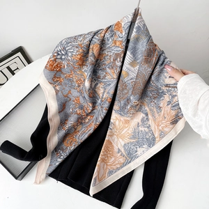 Detail of silk-like scarf featuring jungle wildlife print and contrast rolled edges