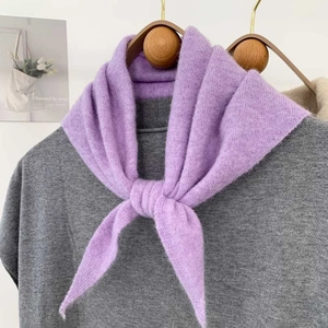 Détail d'une écharpe en tricot violette avec une texture douce et un cintre en bois