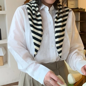 Châle triangulaire rayé en maille sur chemise blanche pour un look d'automne élégant
