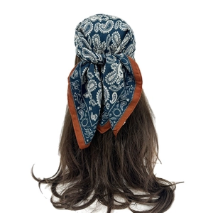 Retro paisley square headscarf in navy blue with orange trim on brown hair for women