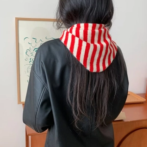 Détail de la texture de l'écharpe en laine à rayures rouges et blanches sur modèle