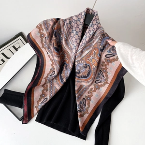 Detail of bohemian paisley silk scarf styled on black knitwear with elegant drape