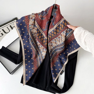 Detail of silk-wool paisley shawl draped on a black sweater for a stylish contrast