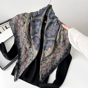 Detail showing smooth silk texture and paisley pattern of navy blue square scarf