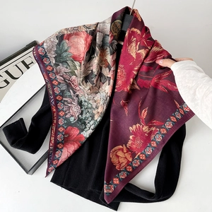 Detail of burgundy floral silk square scarf with vintage patterns on black knitwear