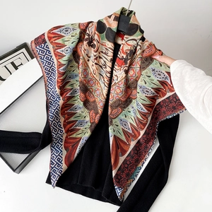 Detailed close-up of a vintage paisley silk scarf styled over a black ribbed sweater