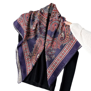 Navy blue paisley silk scarf with satin luster styled on a black sweater mannequin